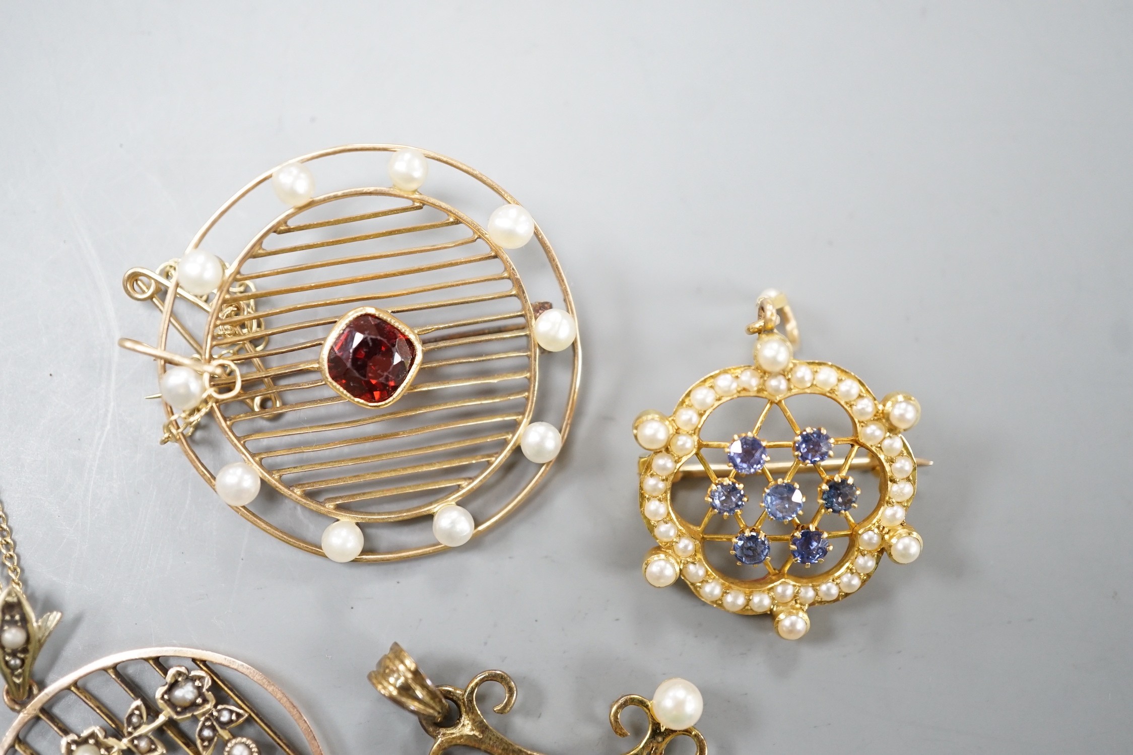 Three early 20th century yellow metal and gem set pendants or brooches, including sapphire and seed pearl, garnet and seed pearl and amethyst and seed pearl on chain and a later 375 garnet and cultured pearl set quatrefo